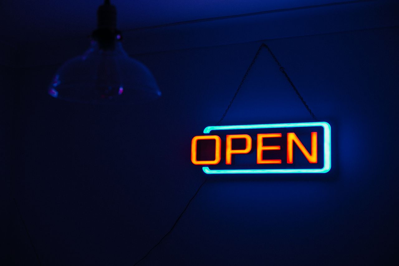 Brightly lit Open neon sign against a dark background, creating a vibrant and inviting atmosphere.